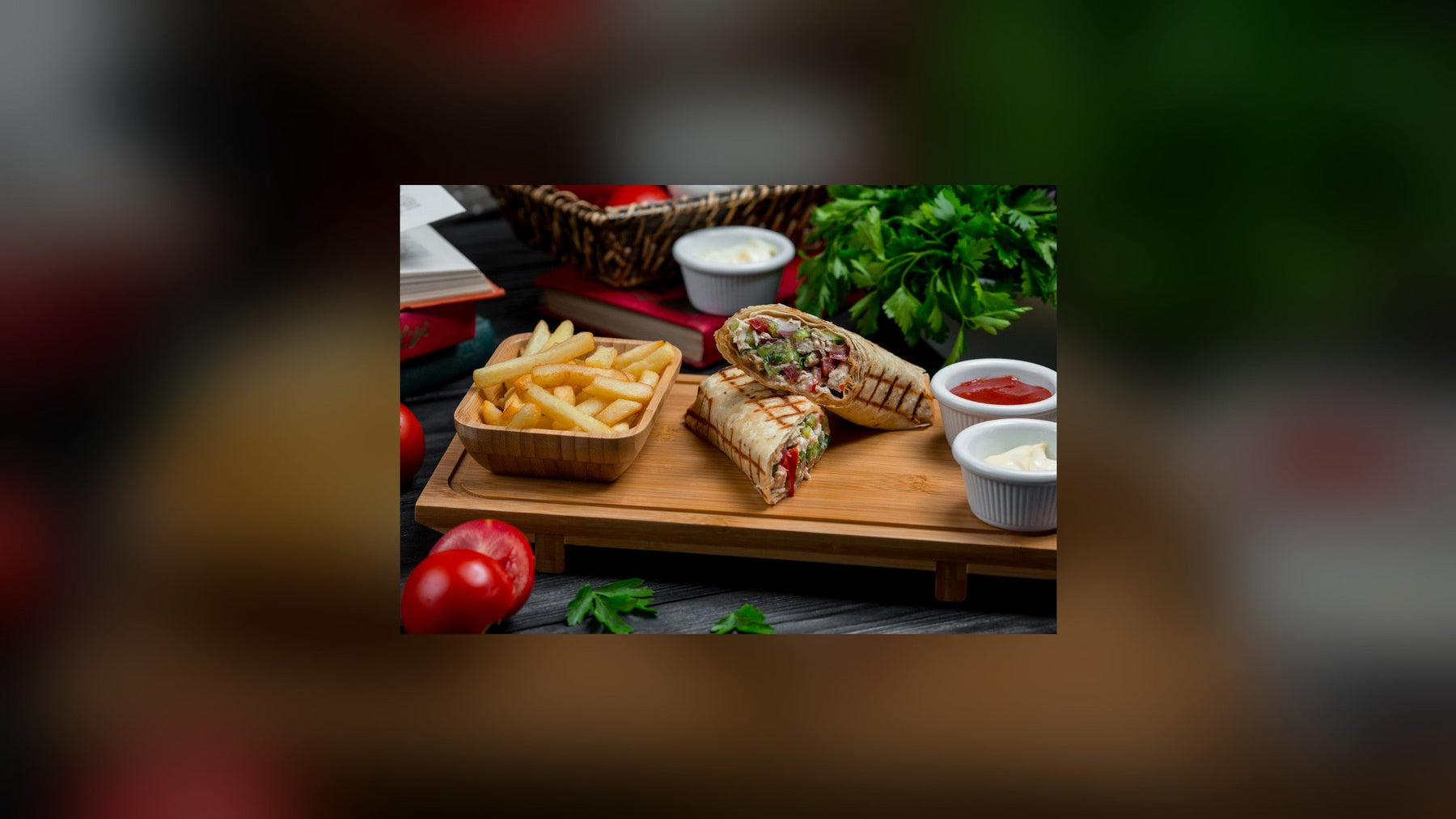 Shawarma wraps with fries and sauces on a serving board
