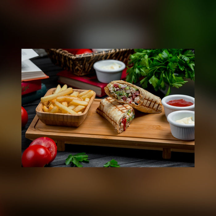 Shawarma wraps with fries and sauces on a serving board